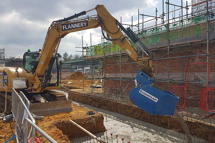 conquip excavator pouring bucket pouring concrete on a house building site