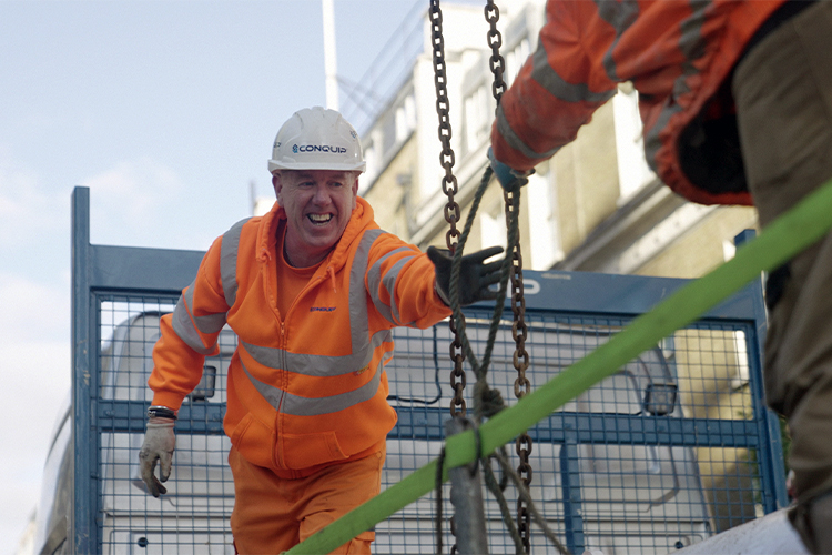 Delivery driver assists unloading temporary works at Cambridge House