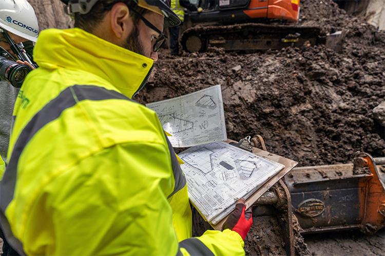 Looking over engineers shoulder as he reads temporary propping plans